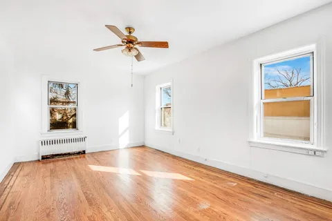 an empty room with a window and a ceiling fan