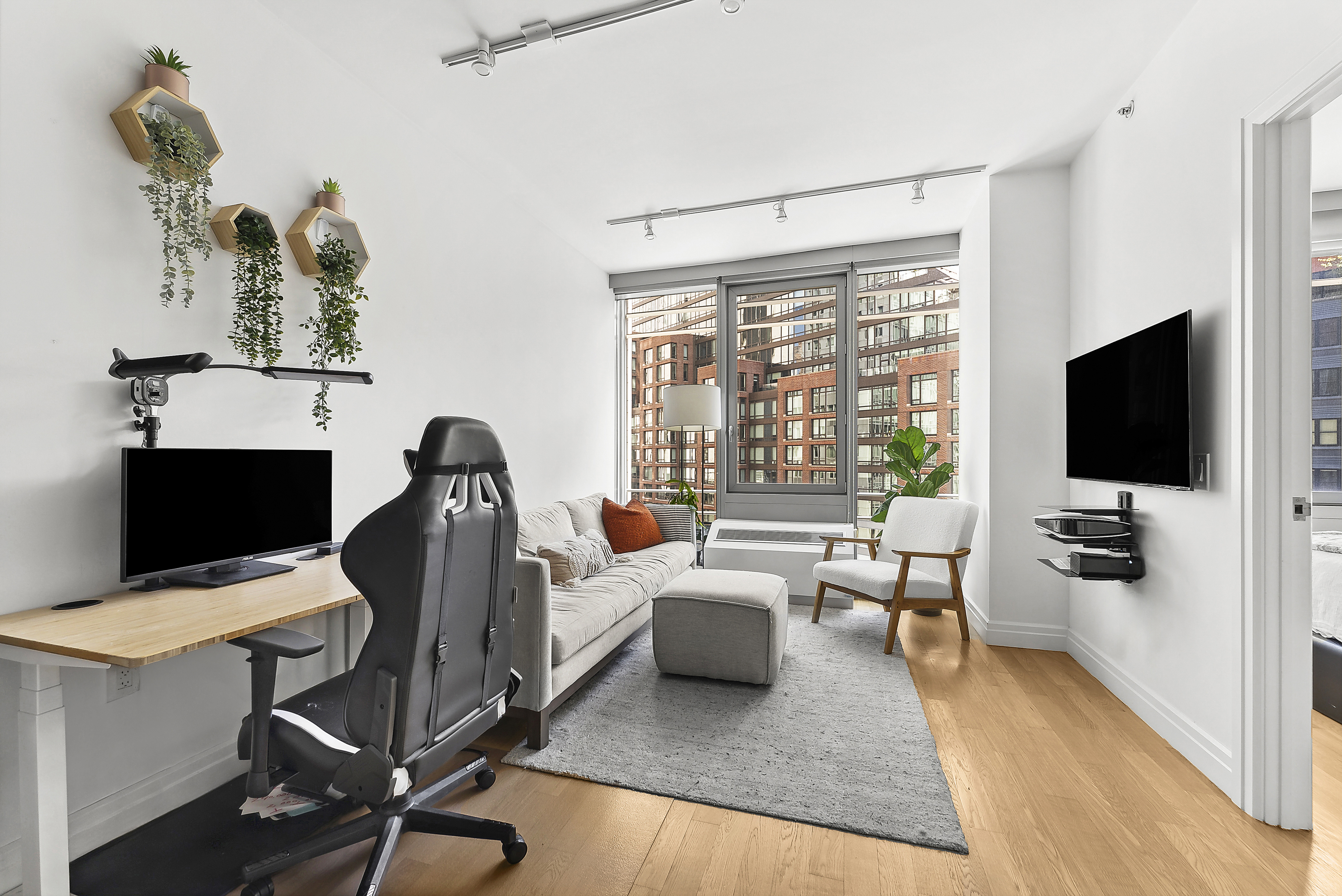 550 West 54th Street, Unit 1030 Manhattan, NY 10019 - Photo 2 of 5 a living room with furniture and a flat screen tv