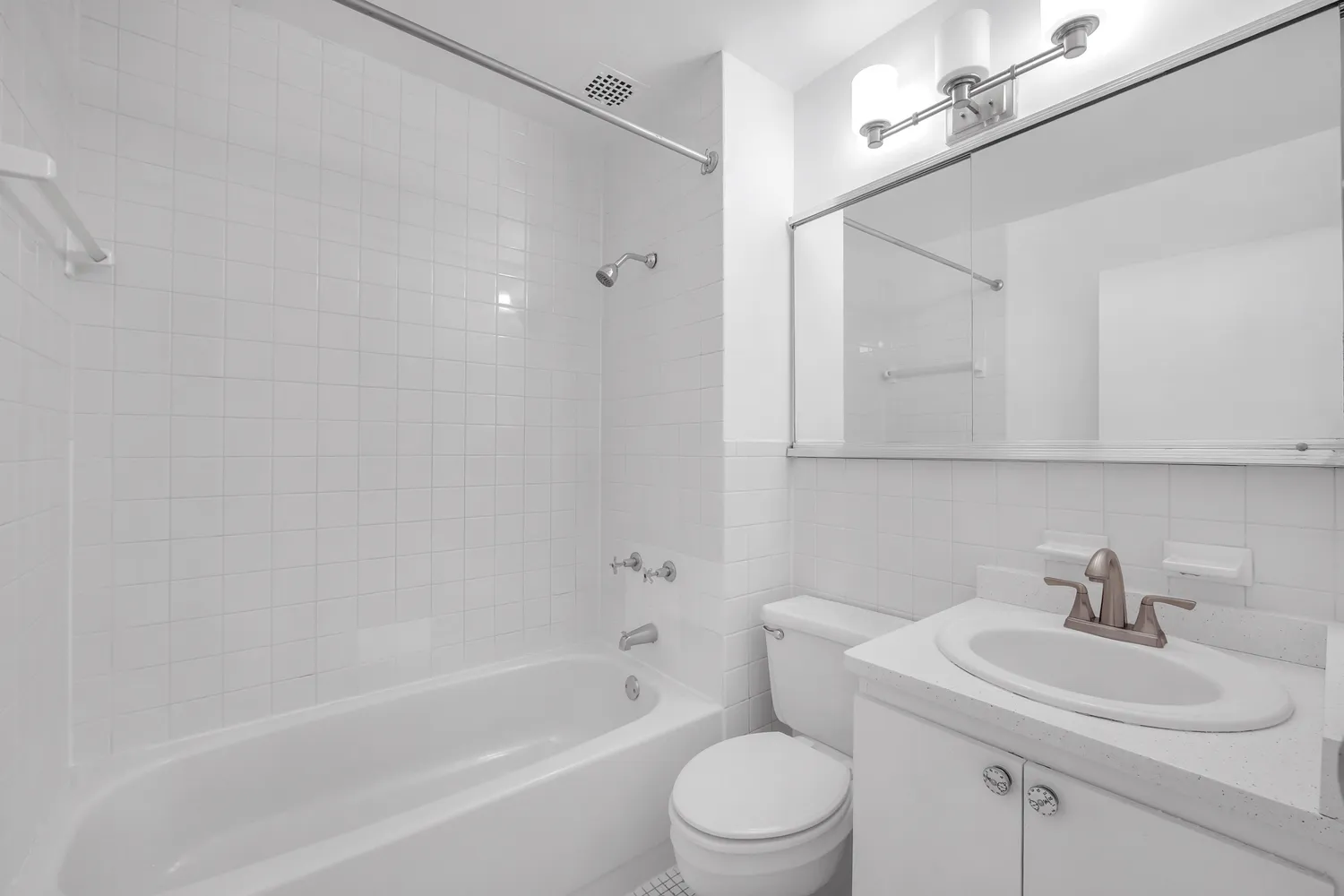 a bathroom with a toilet a sink a mirror and shower