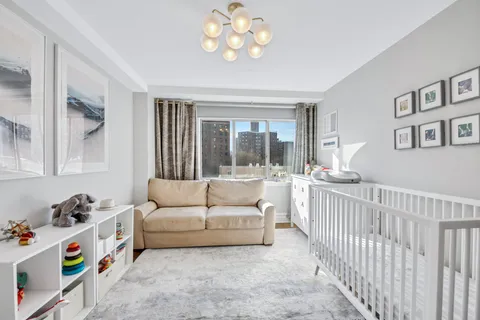 a bedroom with furniture and a large window