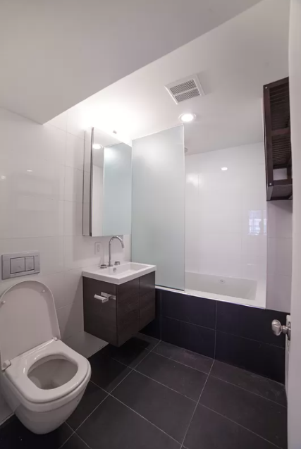 179 Grand Street, Unit 2F Manhattan, NY 10013 - Photo 7 of 13 a bathroom with a sink toilet and mirror