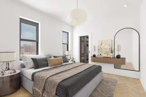 a bedroom with a large bed and a chandelier