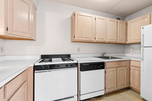 a kitchen with granite countertop white cabinets and white appliances