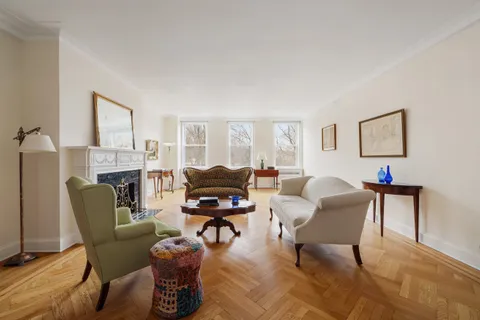 a living room with furniture a fireplace and a window