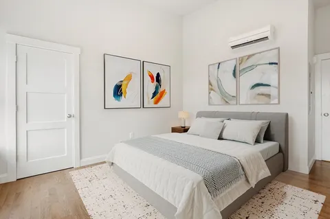 a bedroom with a bed and a painting on the wall