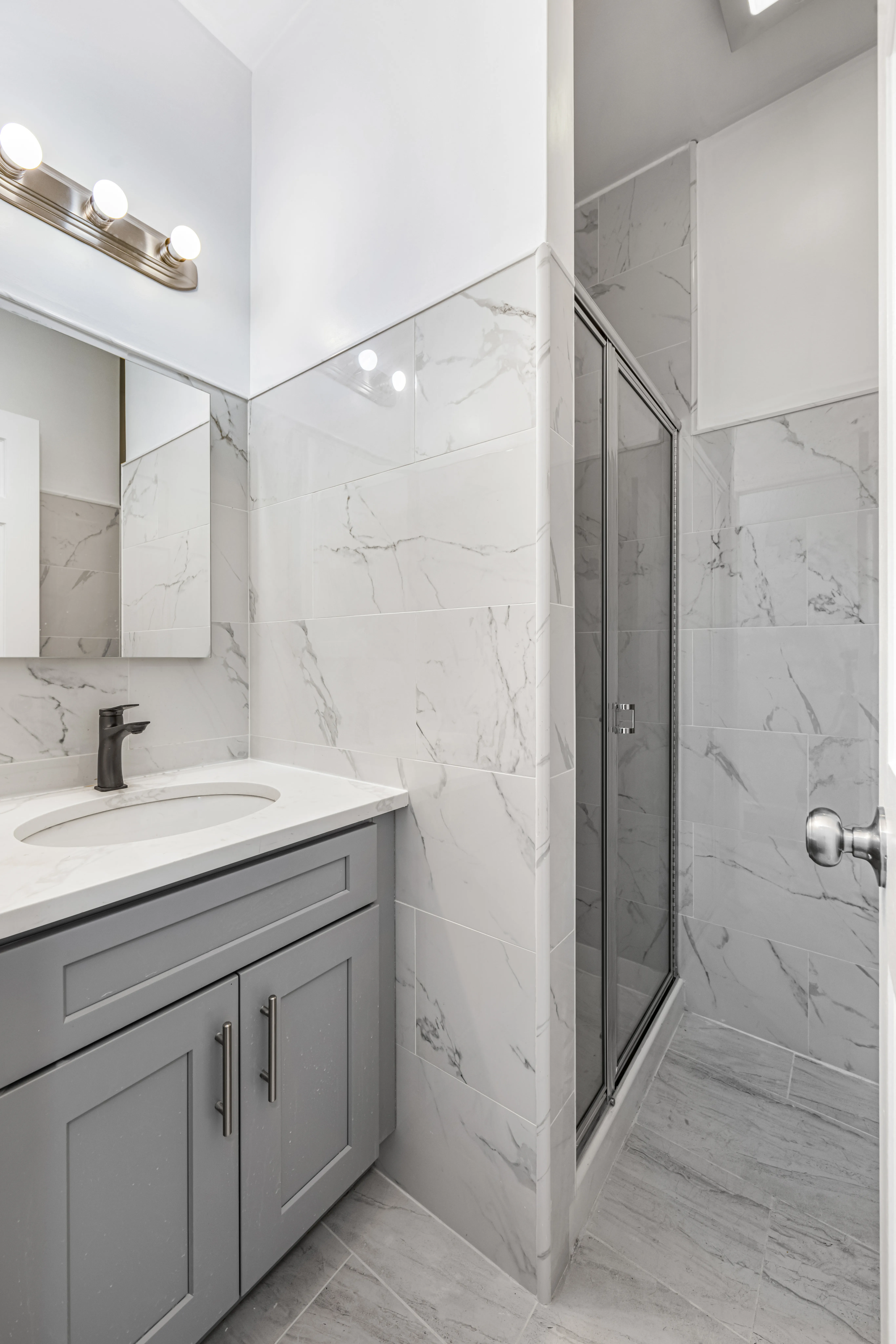 141 23rd Street, Unit 3L Brooklyn, NY 11232 - Photo 9 of 9 a spacious bathroom with a shower sink and mirror