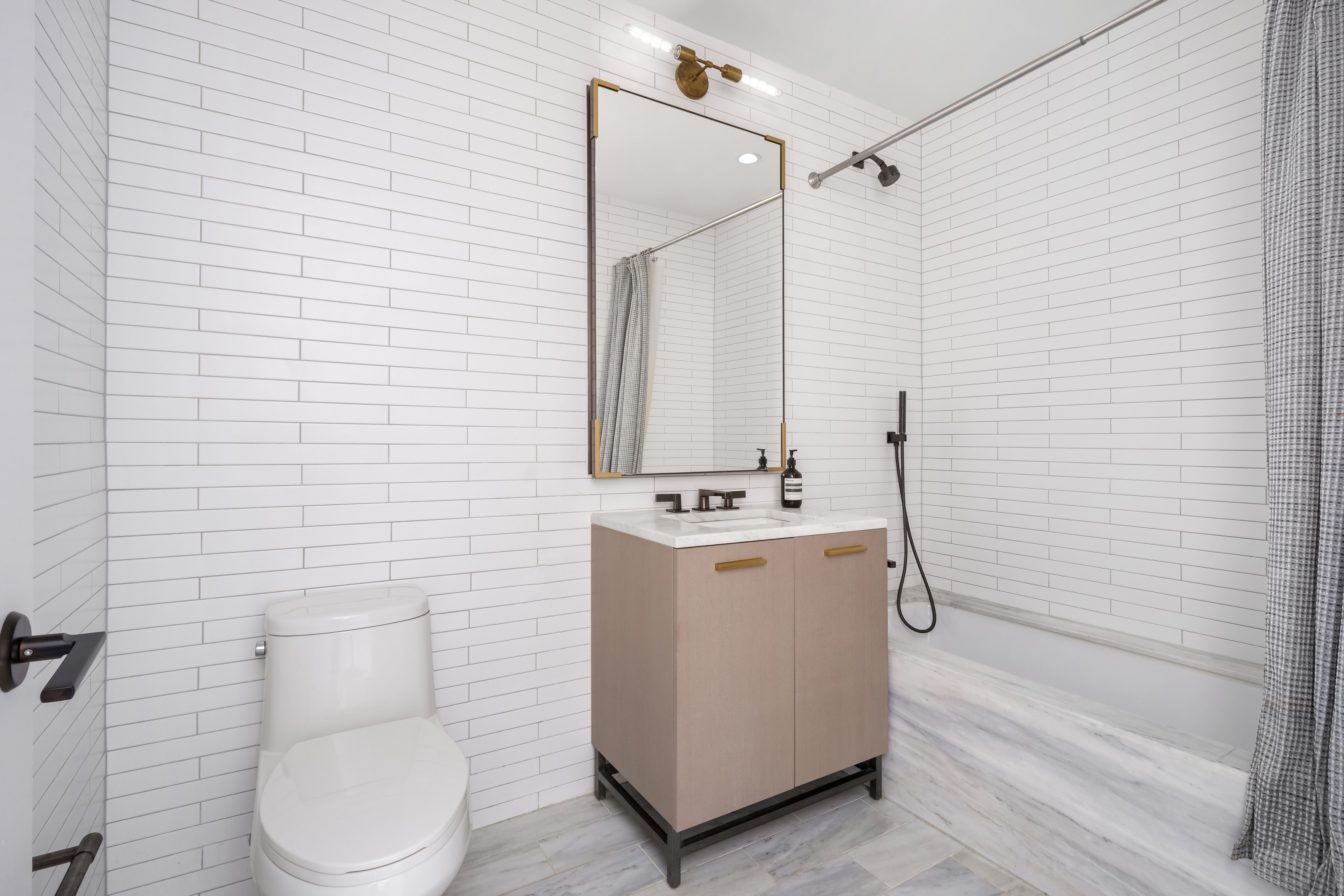 91 Leonard Street, Unit 16B Manhattan, NY 10013 - Photo 10 of 20 a bathroom with a toilet a sink and a mirror