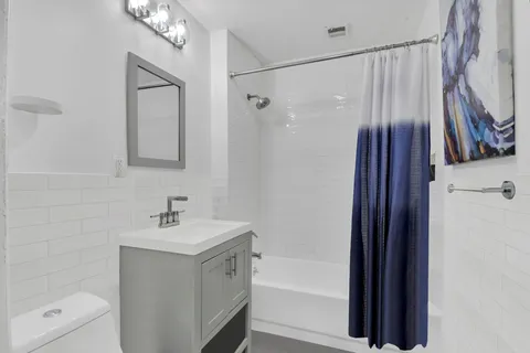 a bathroom with a shower a sink and a mirror