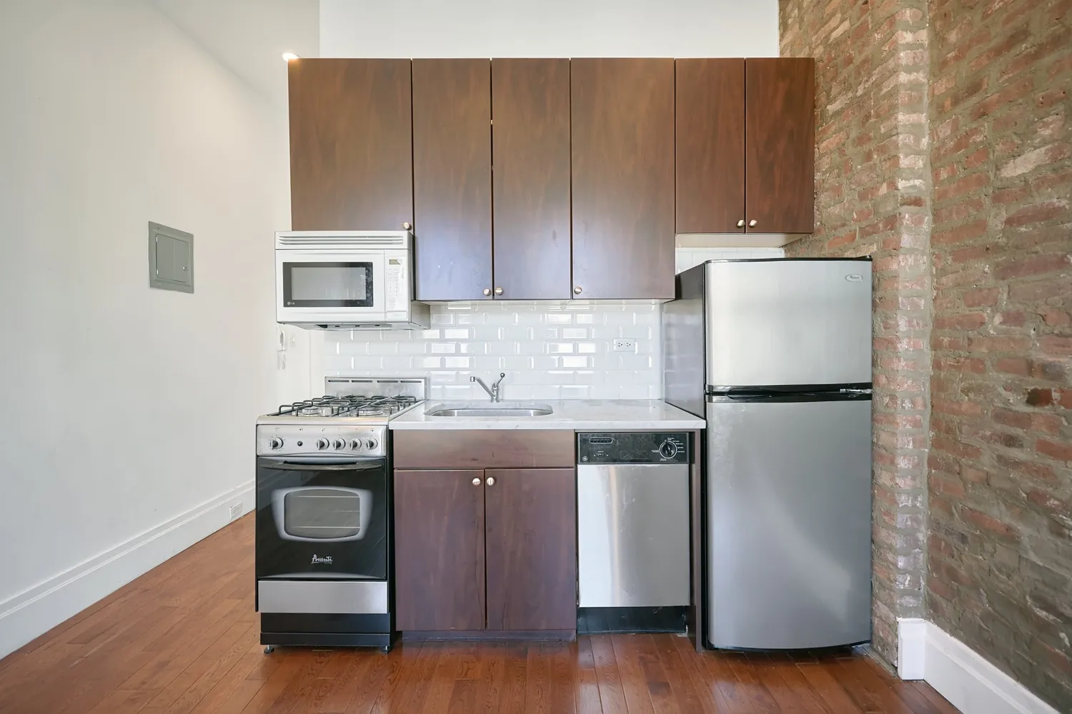 a kitchen with stainless steel appliances granite countertop a refrigerator a stove a sink and a microwave