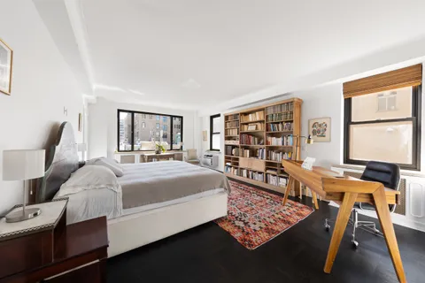a bed room with a bed window and book shelf