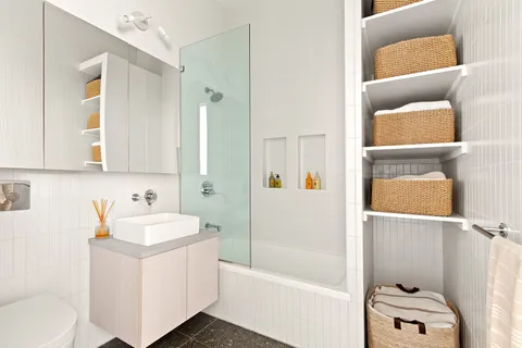 a bathroom with a sink a toilet and shower