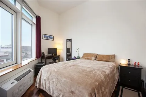 a bed sitting in a bedroom next to a window