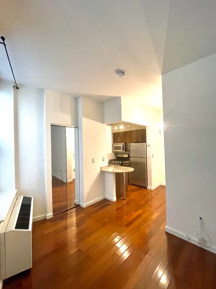 a kitchen with stainless steel appliances kitchen island granite countertop a sink refrigerator and cabinets