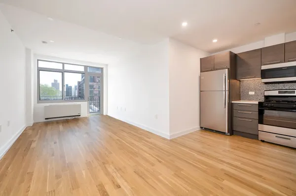 a view of kitchen with wooden floor electronic appliances and windows