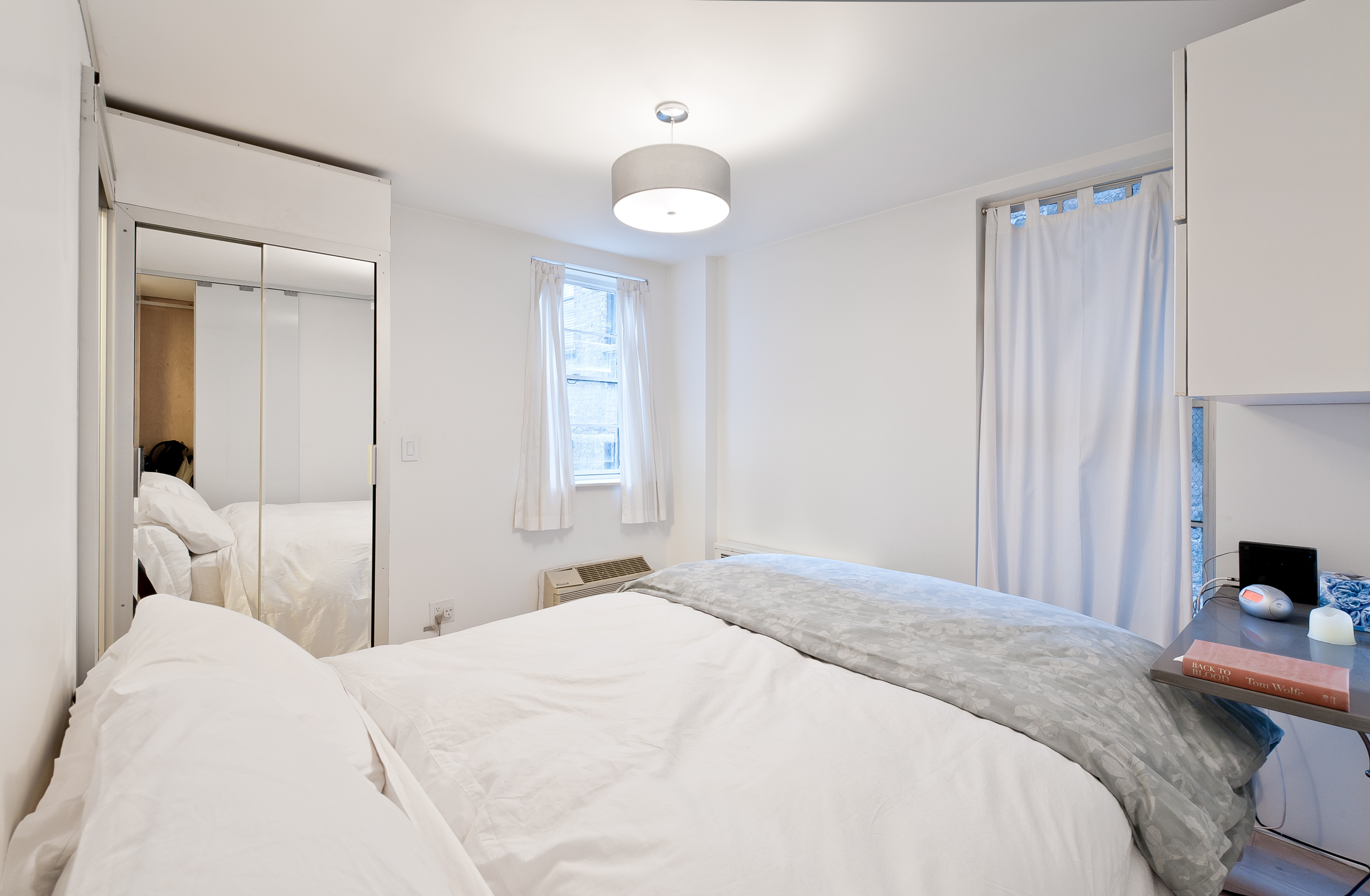 10 Charles Street, Unit 2B Manhattan, NY 10014 - Photo 7 of 8 a bedroom with a bed and a chandelier