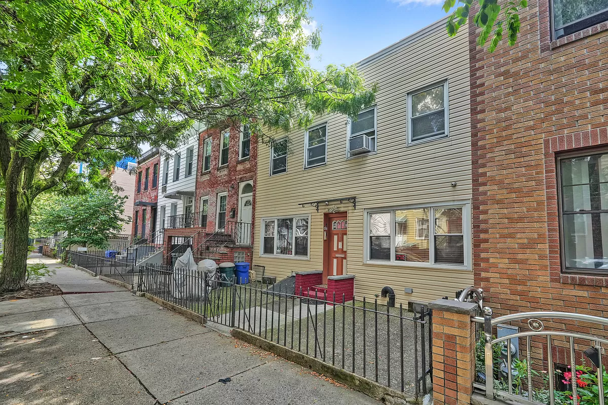 a front view of a house with iron fence