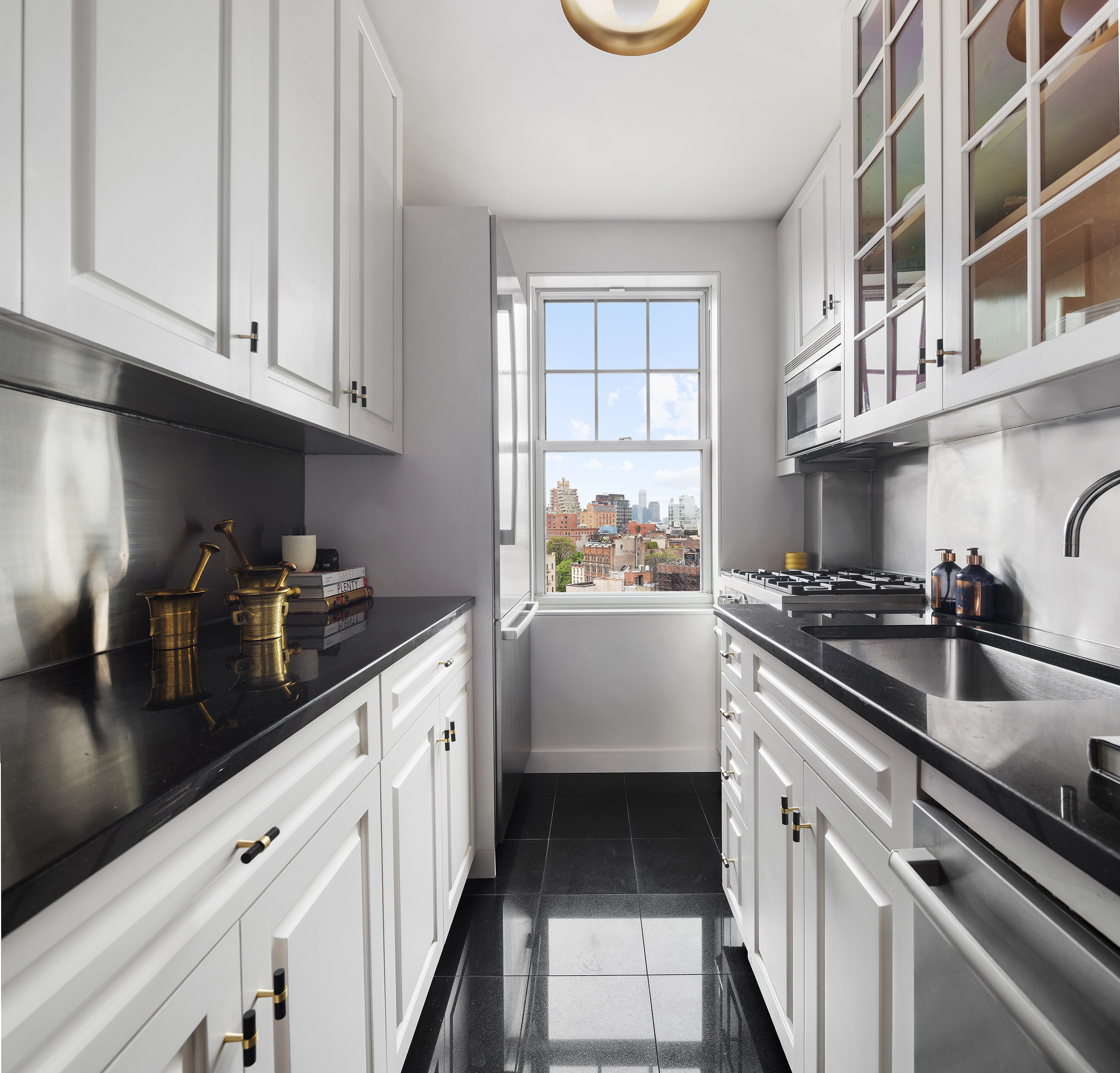 302 West 12th Street, Unit 11F Manhattan, NY 10014 - Photo 8 of 17 a kitchen with stainless steel appliances a sink a stove and cabinets