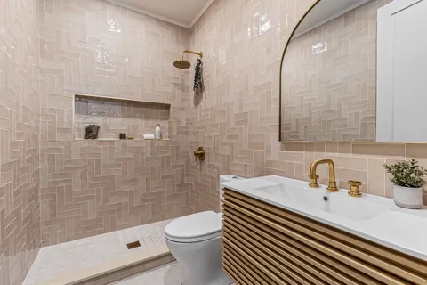 a bathroom with a sink a toilet and shower