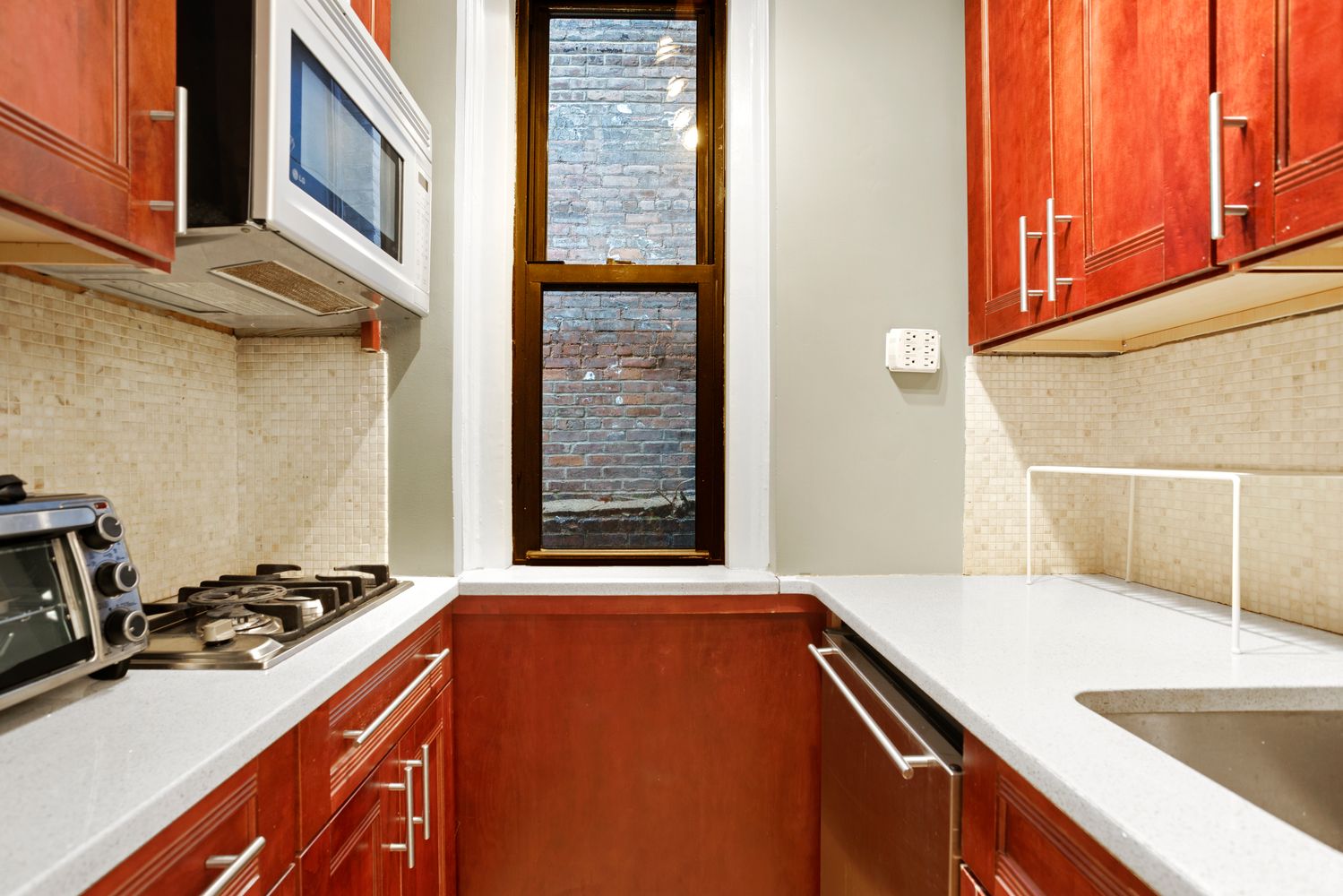 22 Grove Street, Unit 1F Manhattan, NY 10014 - Photo 6 of 9 a view of a kitchen with a sink and a refrigerator