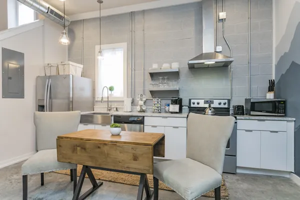 a kitchen with a table chairs sink and cabinets