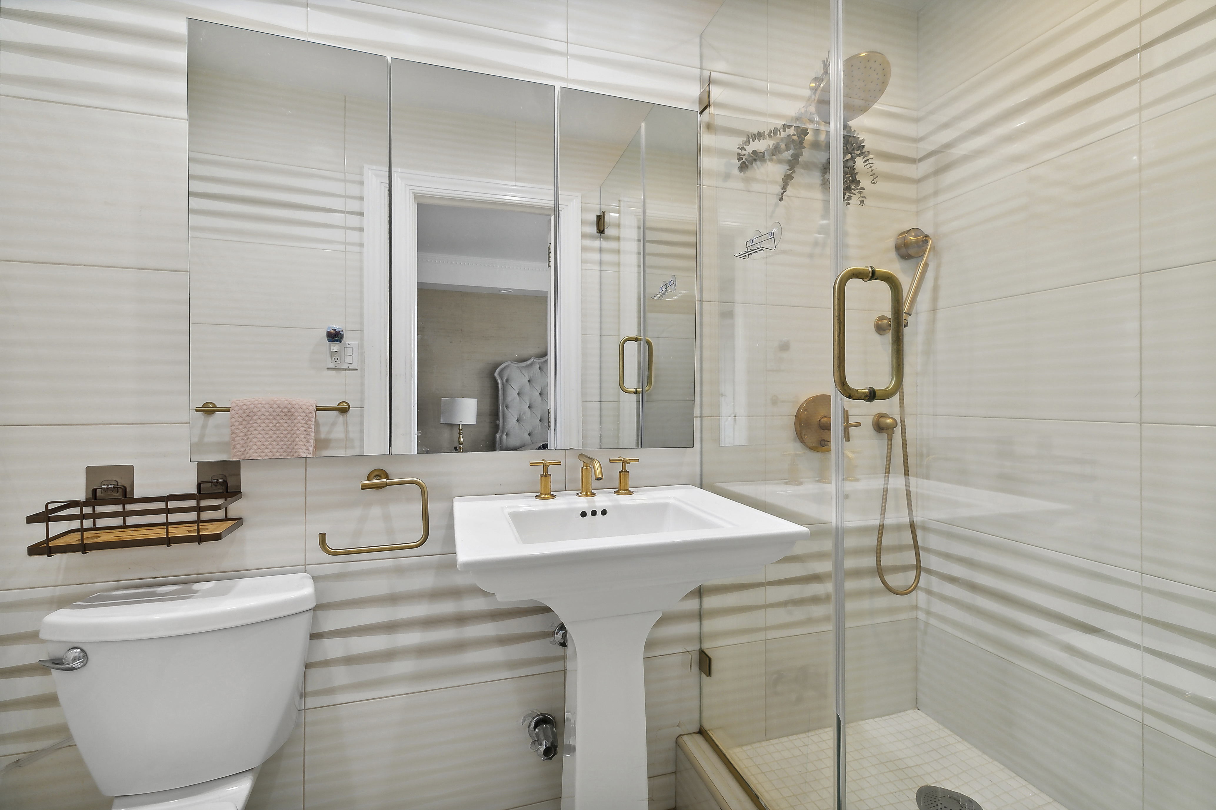 303 East 57th Street, Unit 11L Manhattan, NY 10022 - Photo 7 of 11 a bathroom with a sink a toilet a mirror and shower