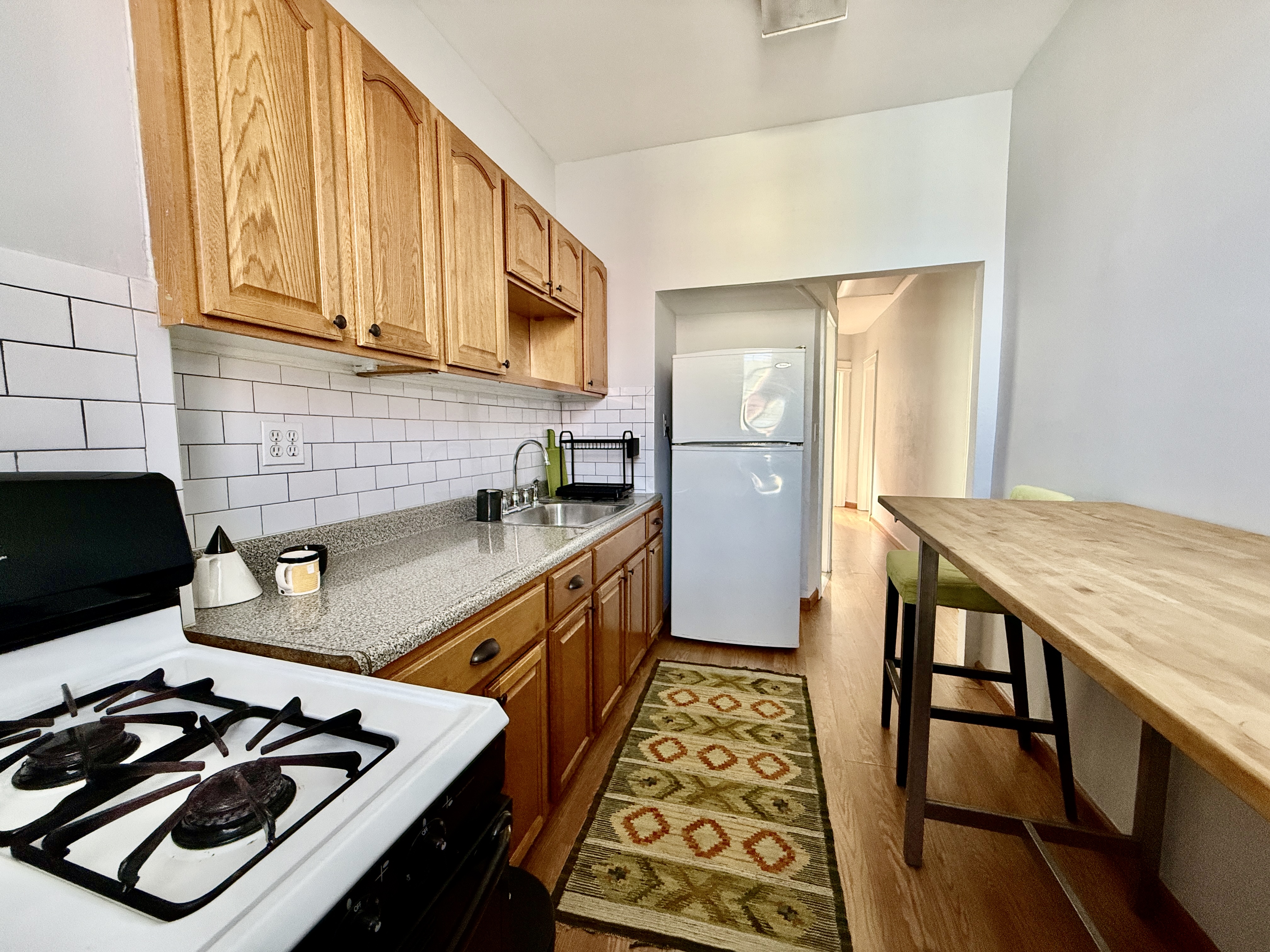 149 East 35th Street, Unit 2 Brooklyn, NY 11203 - Photo 5 of 10 a kitchen with wooden cabinets stove and refrigerator