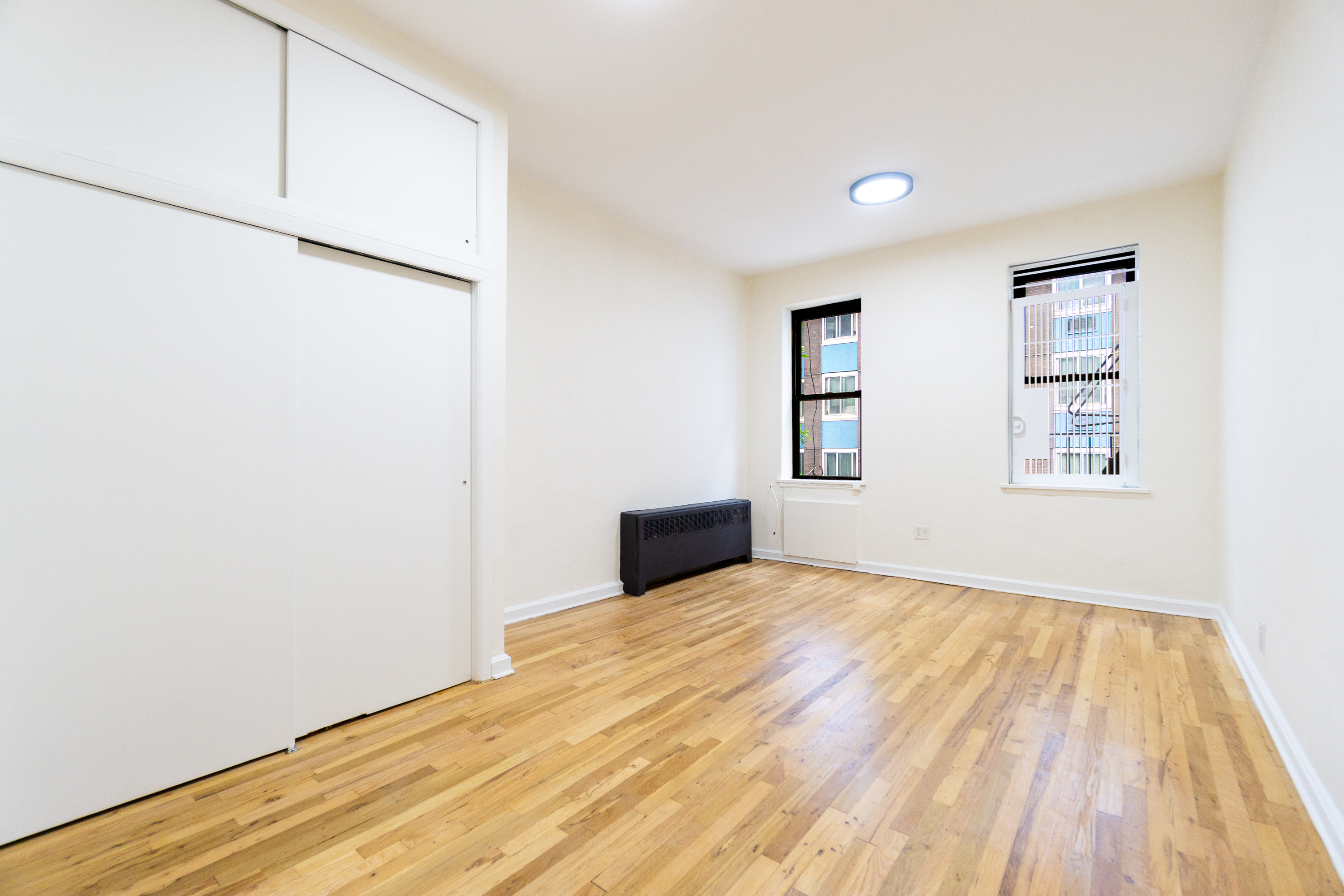 319 East 25th Street, Unit 5C Manhattan, NY 10010 - Photo 2 of 14 a view of a room with wooden floor and white walls