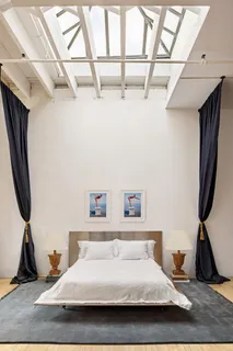 a bedroom with a bed a dresser and a flat screen tv