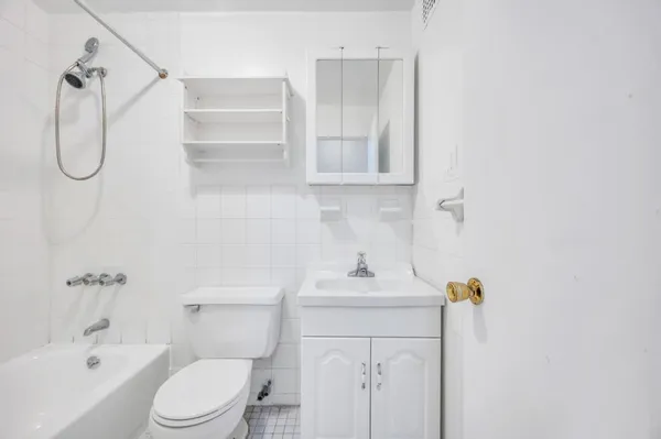 a bathroom with a toilet sink vanity and tub