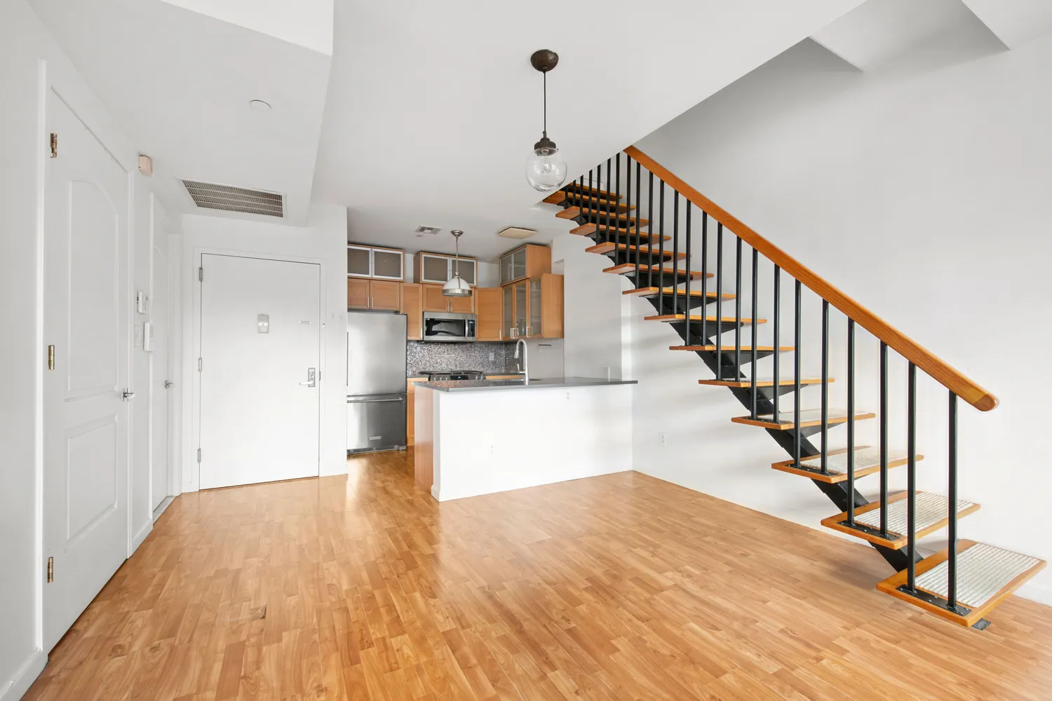 a view of a kitchen with wooden floor and stairs