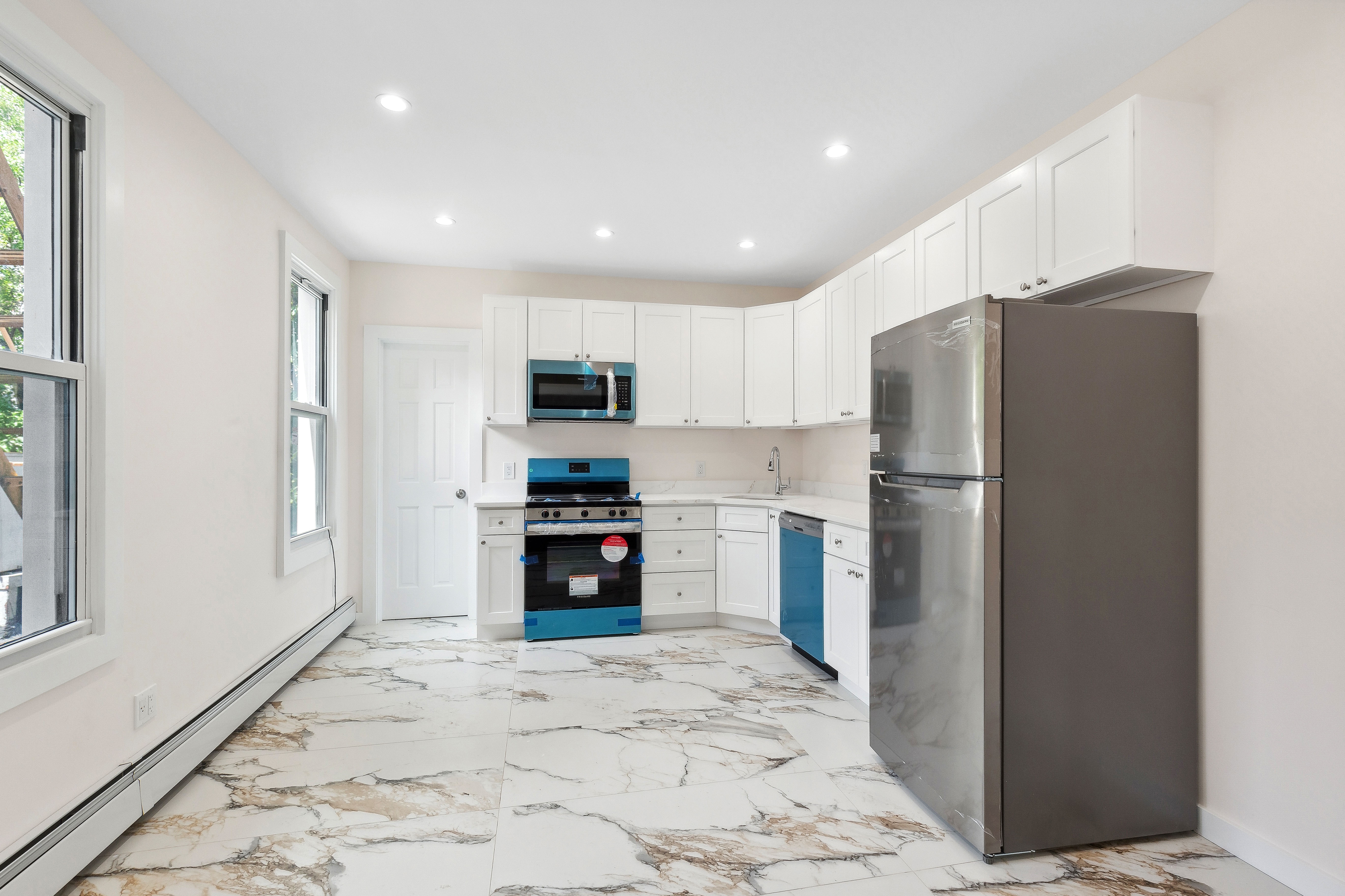 63 Devoe Street, Unit 3 Brooklyn, NY 11211 - Photo 3 of 7 a kitchen with granite countertop a refrigerator and a stove top oven