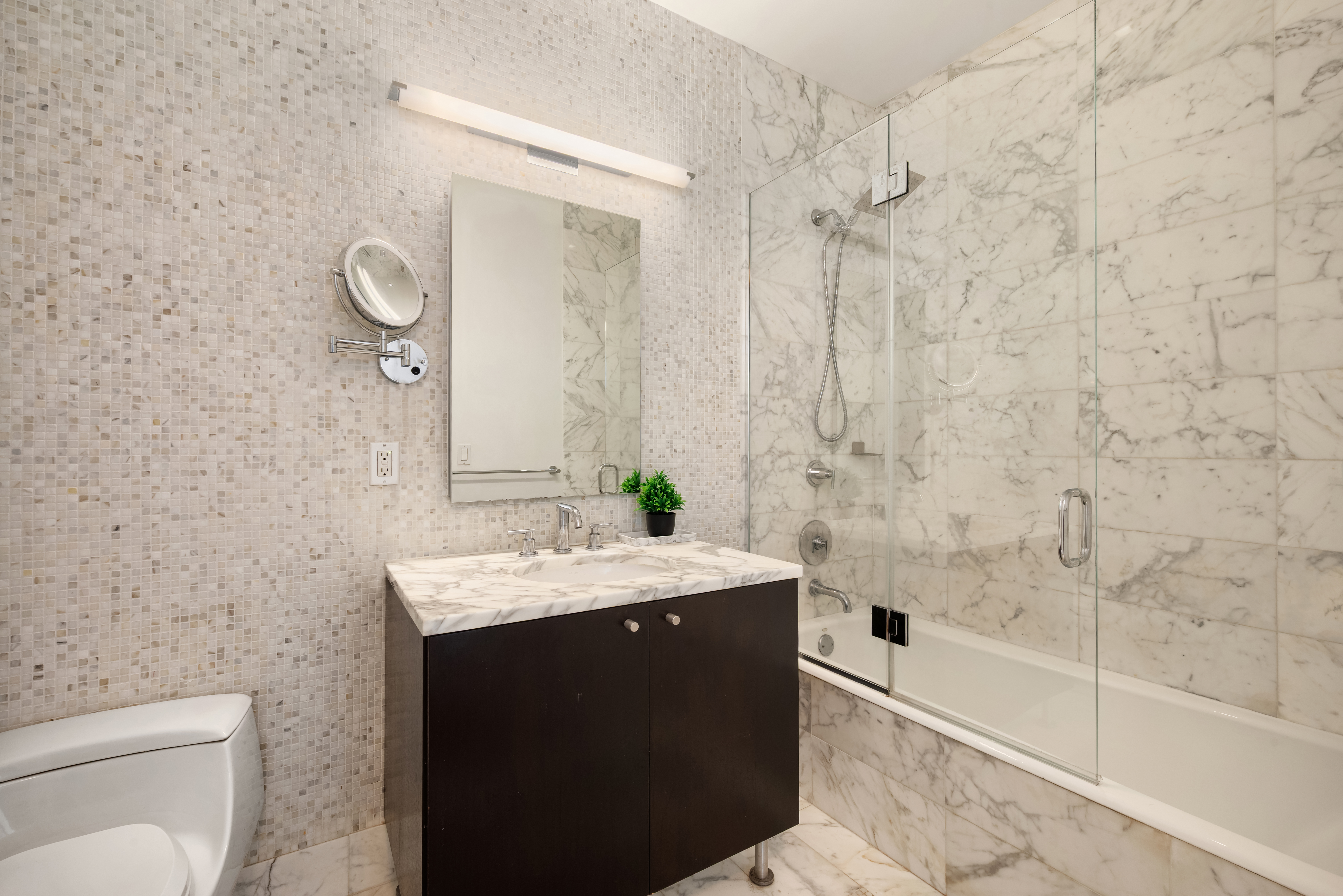 46-30 Center Boulevard, Unit 707 Queens, NY 11109 - Photo 11 of 23 a bathroom with a granite countertop sink a toilet and bathtub