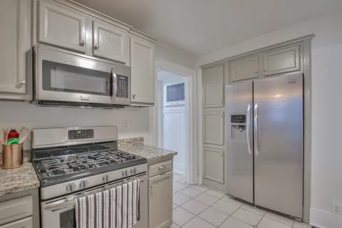 a bedroom with a large bed couch and windows