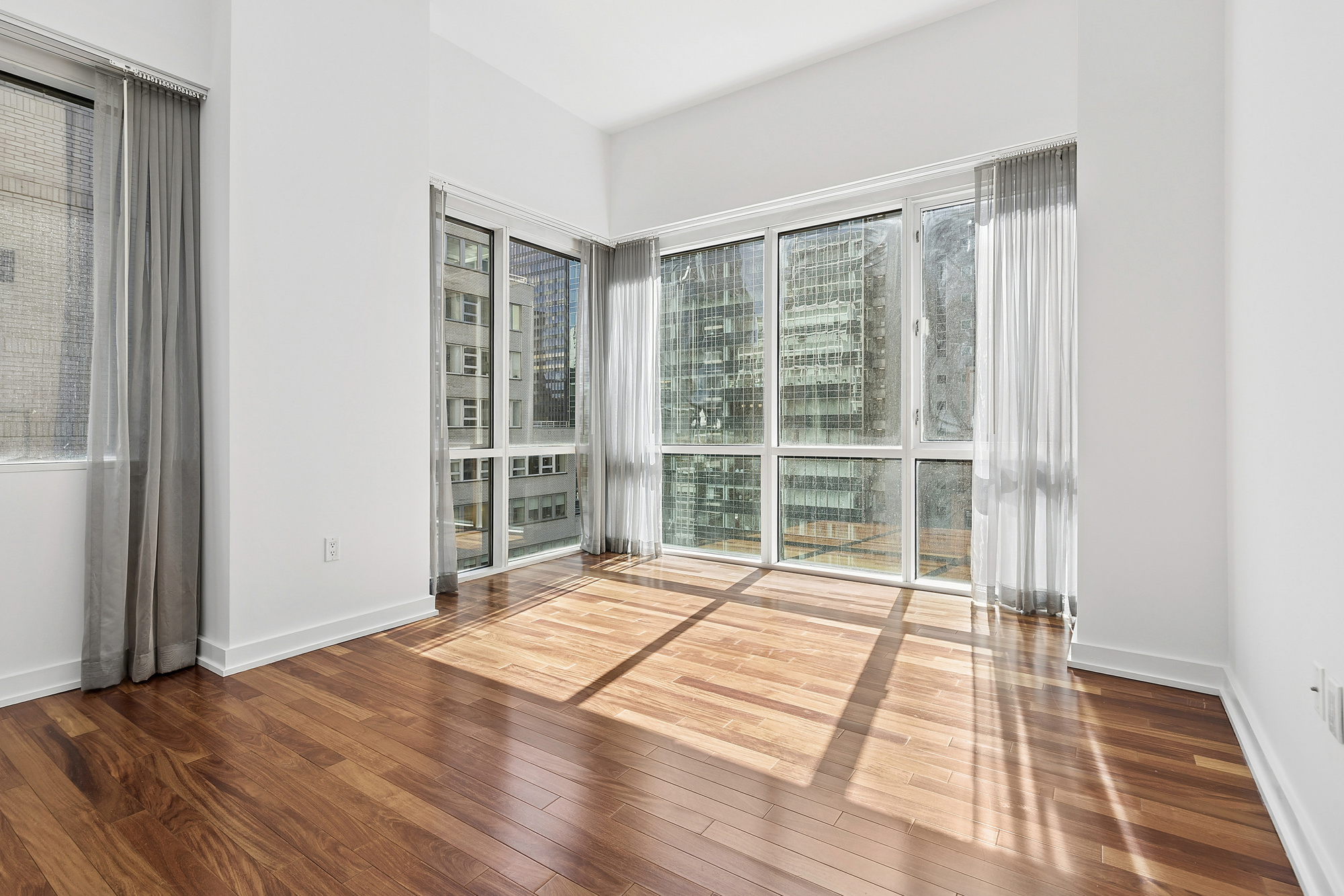 60 East 55th Street, Unit 20A Manhattan, NY 10022 - Photo 6 of 9 a bedroom with a bed and a large window