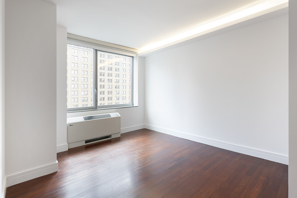 30 West Street, Unit 21AB Manhattan, NY 10004 - Photo 8 of 17 an empty room with wooden floor and windows