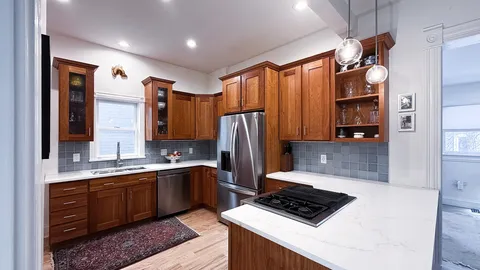 a kitchen with stainless steel appliances granite countertop a sink refrigerator and cabinets