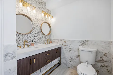 a bathroom with a toilet a sink and a mirror