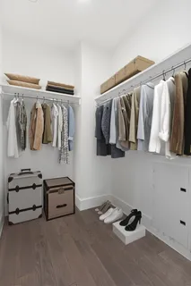a view of walk in closet with clothes and shoes