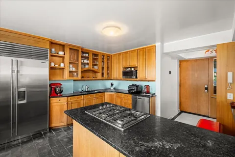 a kitchen with stainless steel appliances granite countertop a refrigerator and a sink