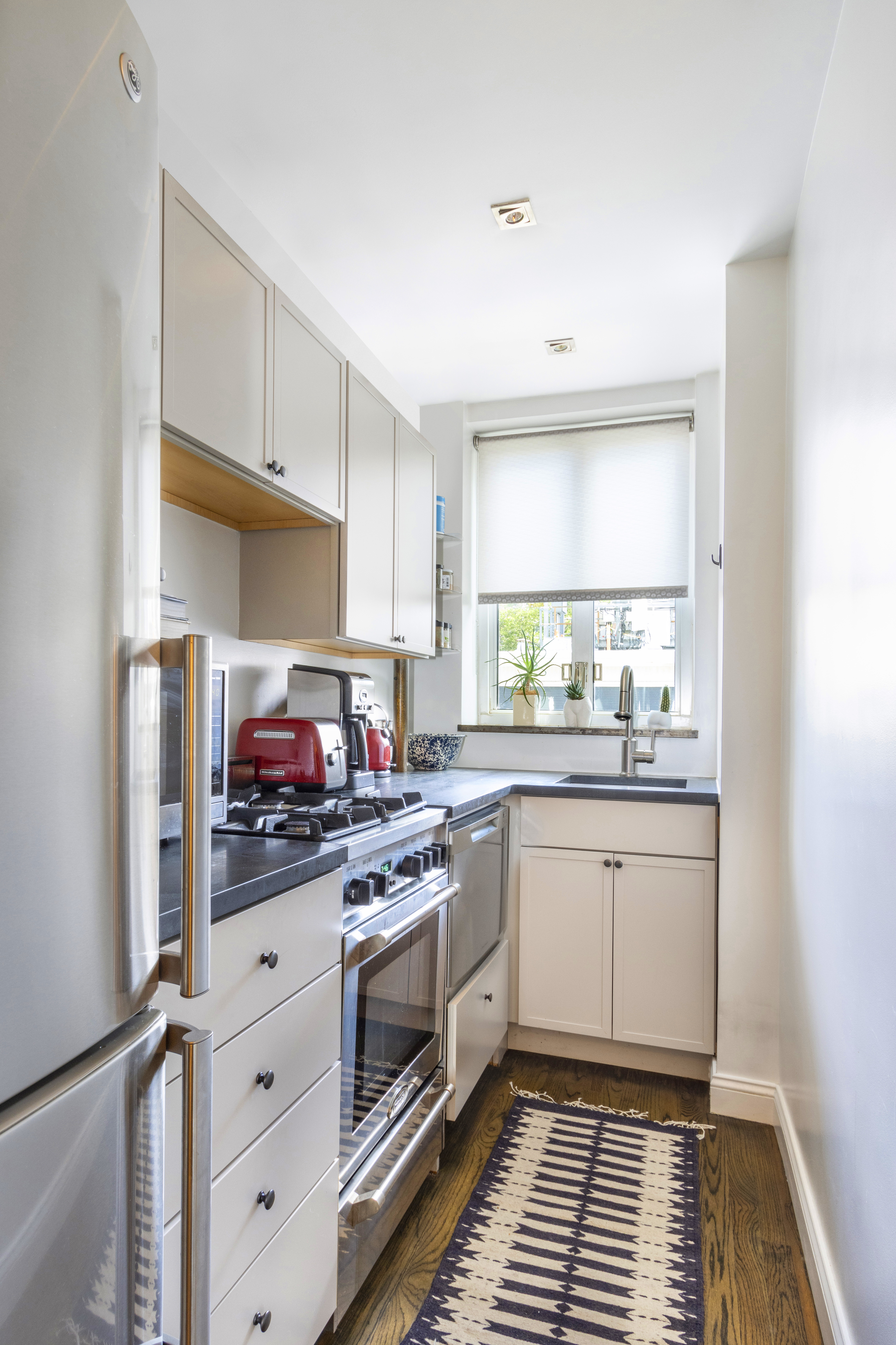 200 West 20th Street, Unit 508 Manhattan, NY 10011 - Photo 3 of 6 a kitchen with granite countertop a stove sink and cabinets