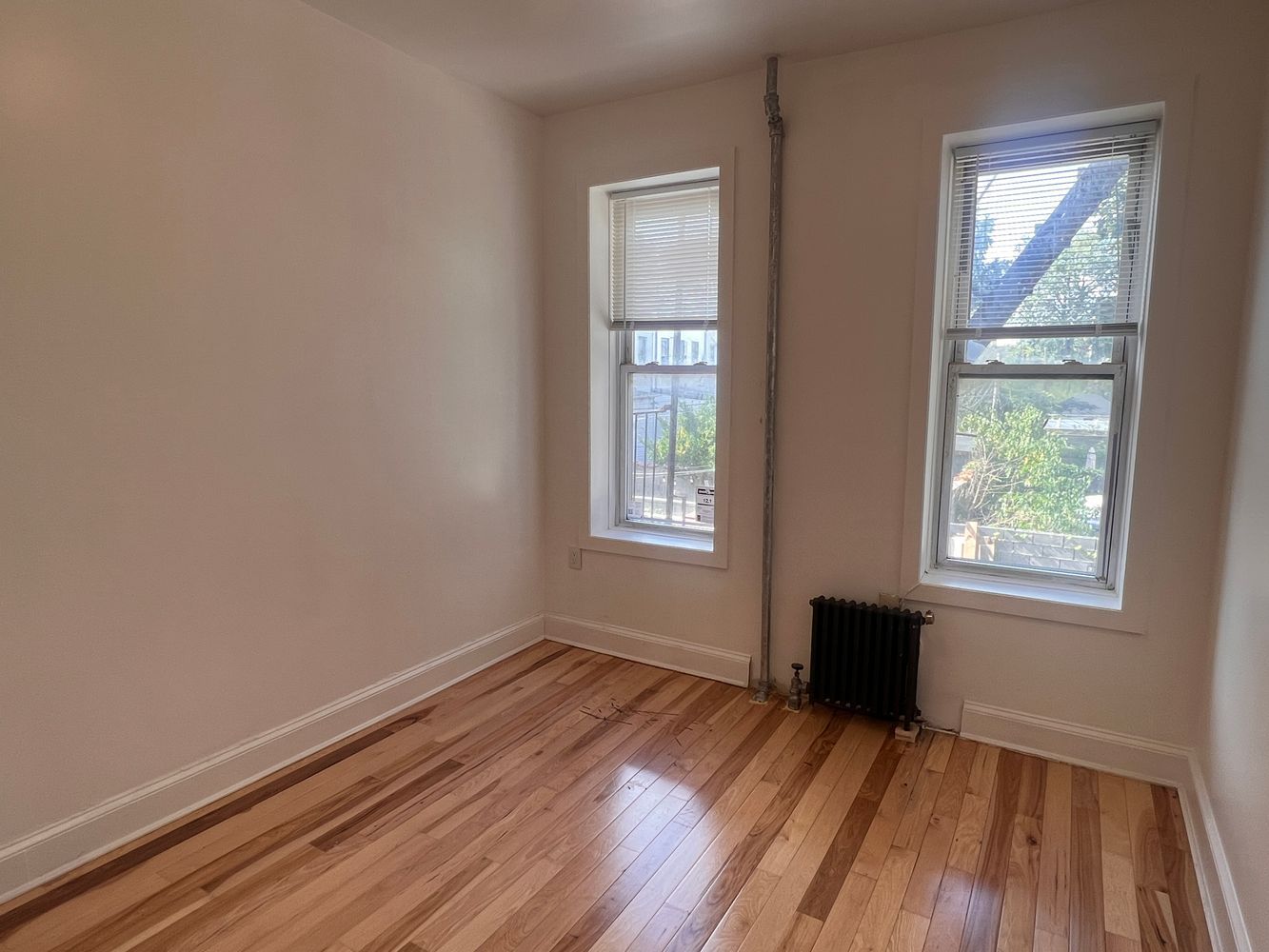 1218 Nostrand Avenue, Unit 1 Brooklyn, NY 11225 - Photo 4 of 5 an empty room with wooden floor and windows
