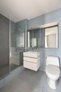 a bathroom with a toilet a sink and mirror