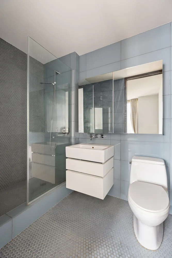 a bathroom with a toilet a sink and mirror