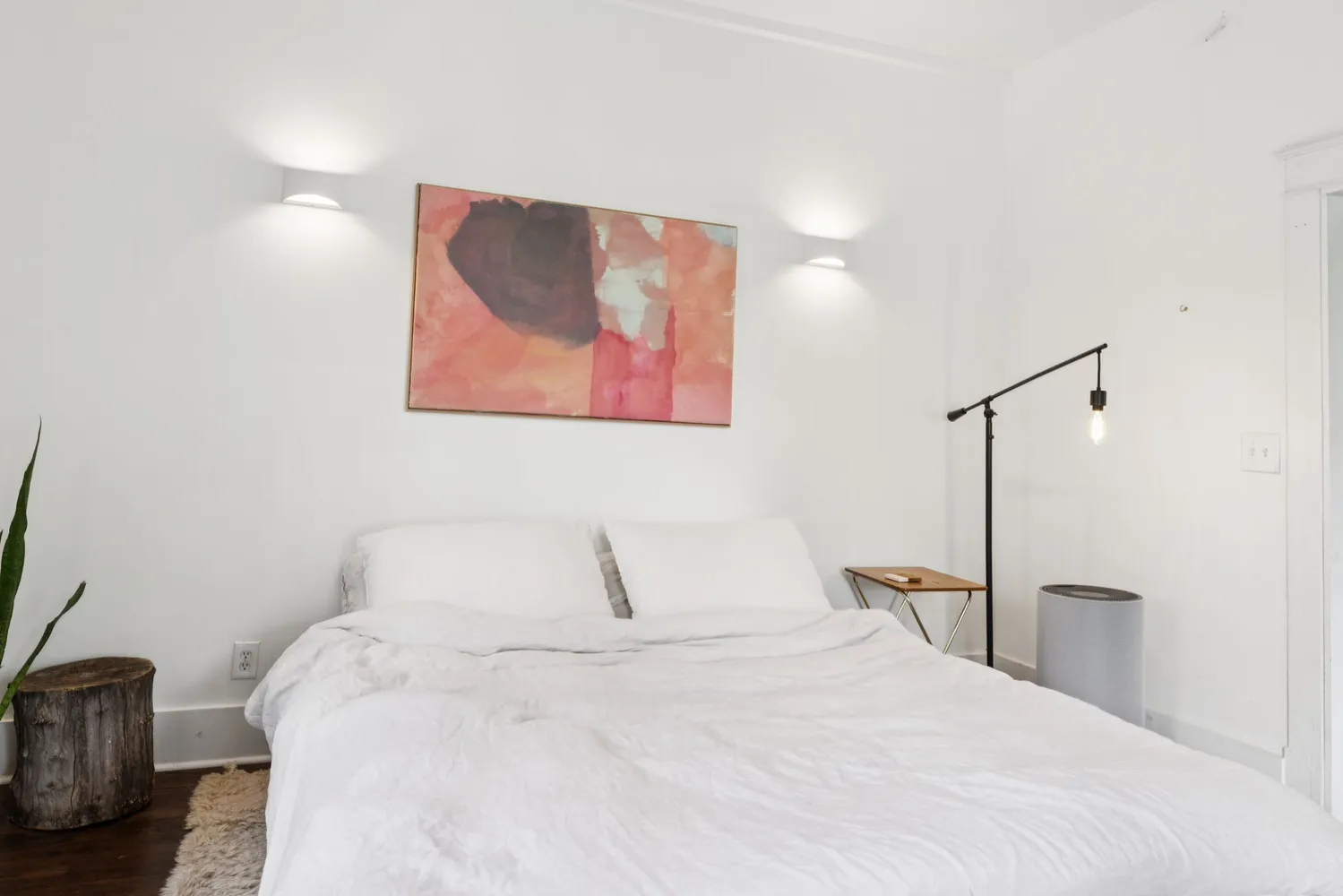 a bedroom with a bed and a painting on the wall