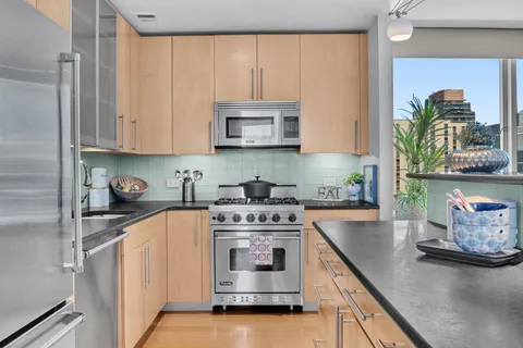 a kitchen with stainless steel appliances granite countertop a stove a sink and a microwave