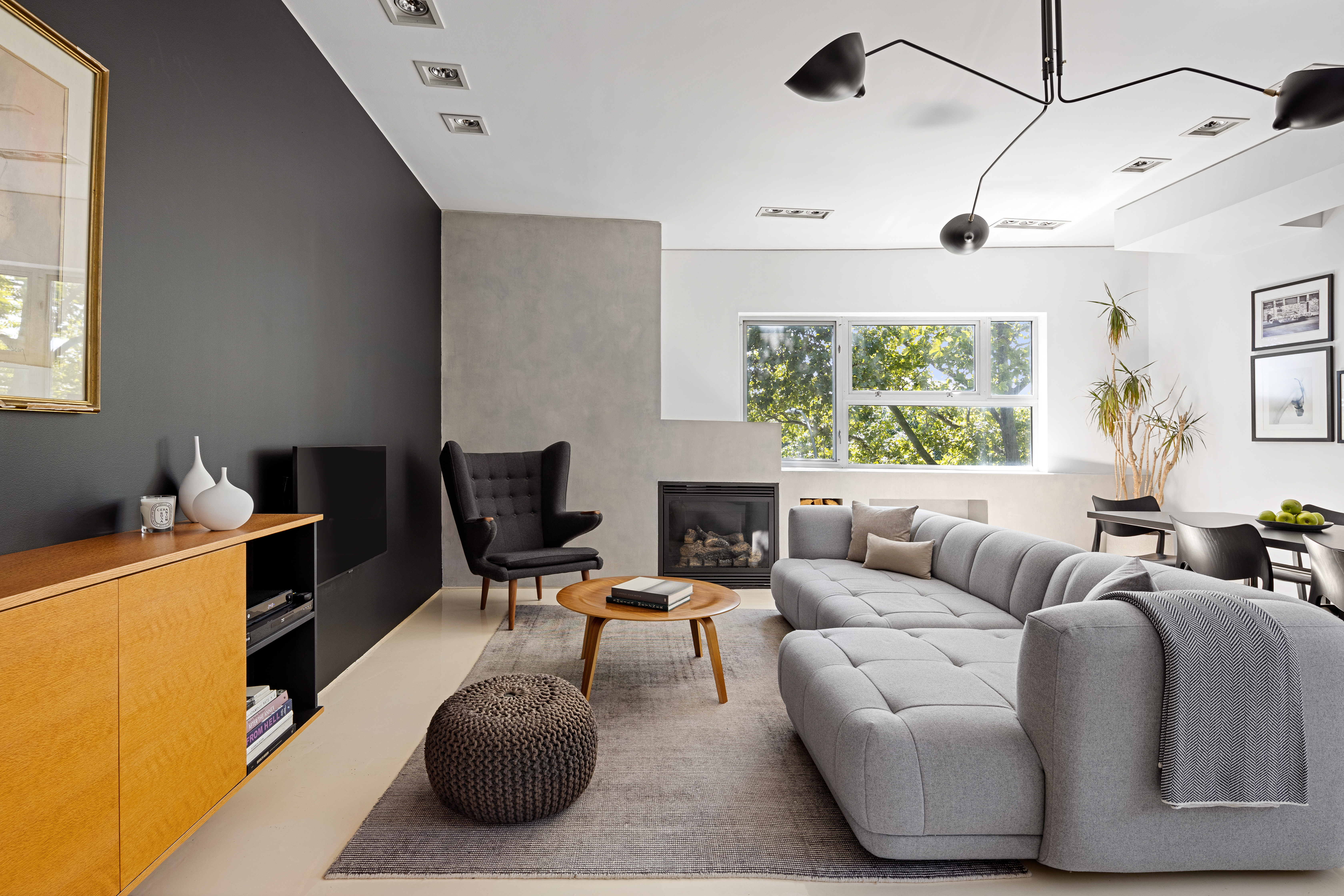 a living room with furniture a large window and a chandelier