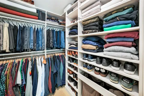 a view of walk in closet with clothes and shoes
