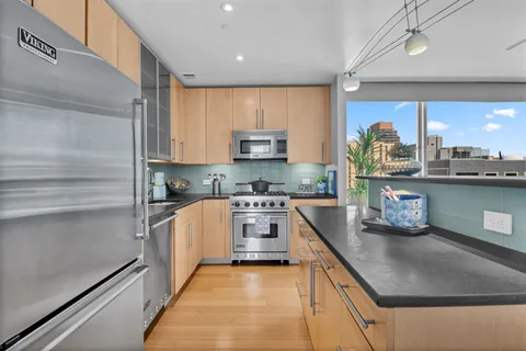 a kitchen with stainless steel appliances granite countertop a stove a sink and a refrigerator