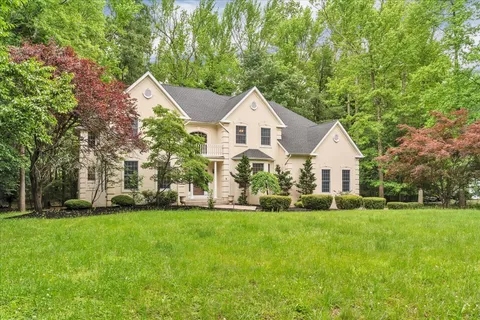a front view of a house with a yard and trees