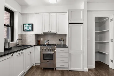 a kitchen with white cabinets and a stove